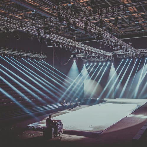 An expansive indoor stage with dramatic lighting setup, ready for a performance or event.